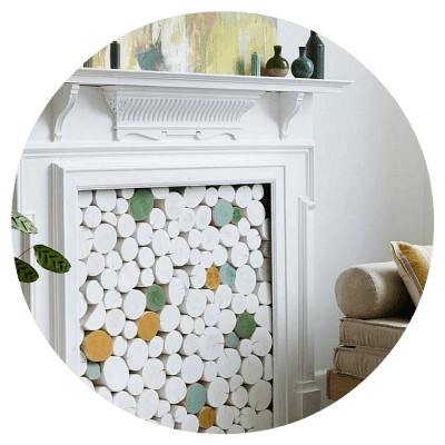 Custom colour mix decorative logs from The Log Basket to match the artwork above the fireplace styled in Ideal Home UK magazine