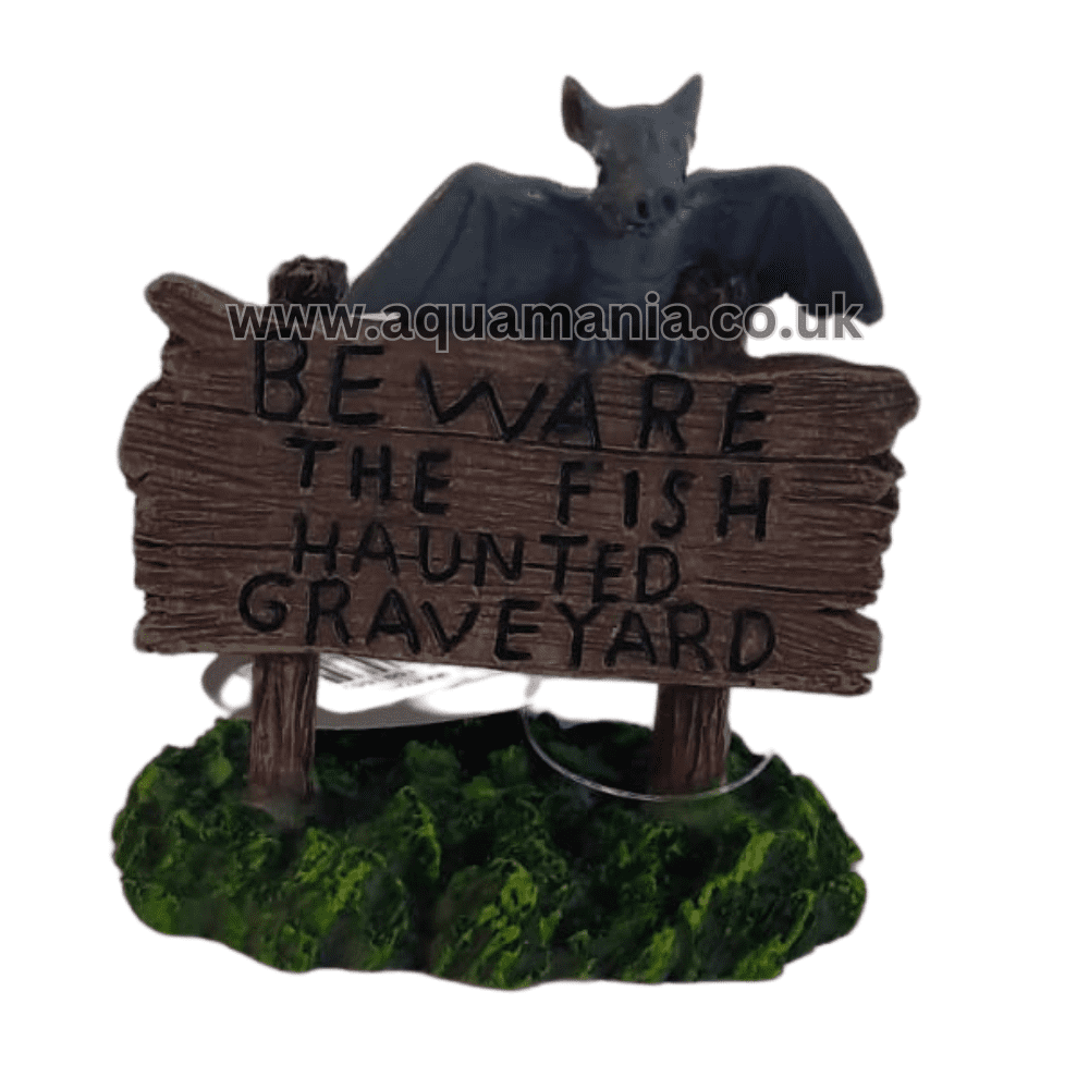 A bat stands on top of a sign that says "Beware the fish, haunted graveyard" aquarium ornament