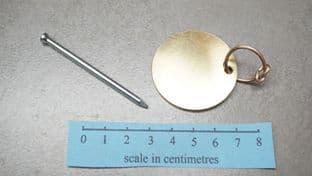 Roman brass round signaculum or baggage label with dot stamping punch