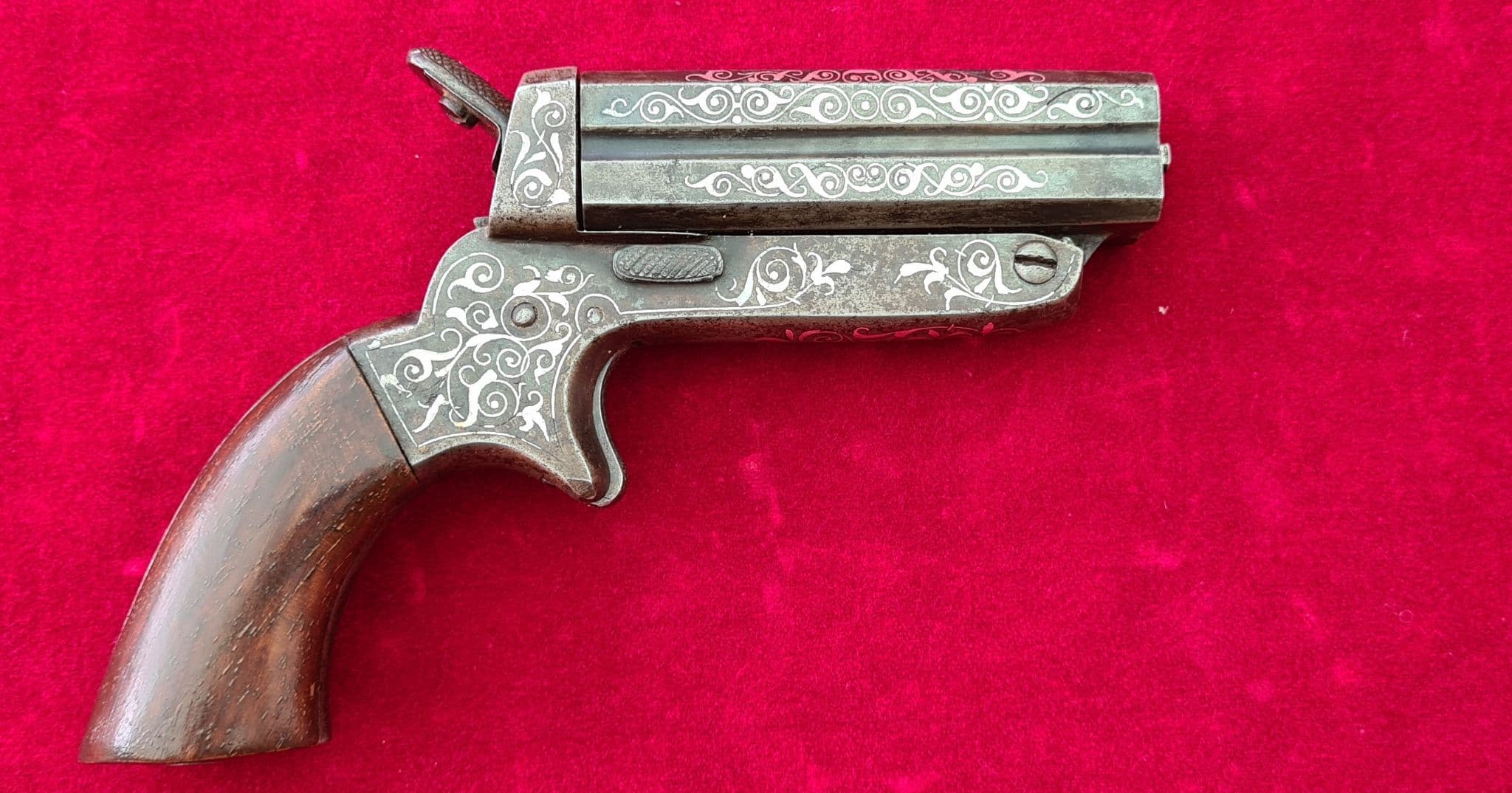 A very fine example of a silver inlaid four barrel 32 cal rimfire