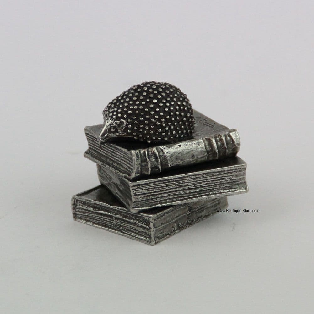 Hérisson en étain sur pile de livres