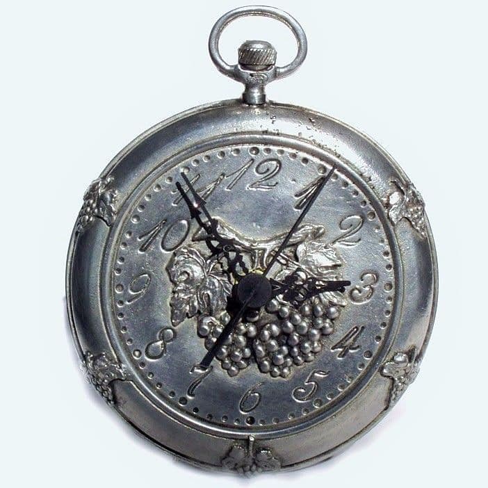 Horloge pendule en étain forme gousset motif vigne