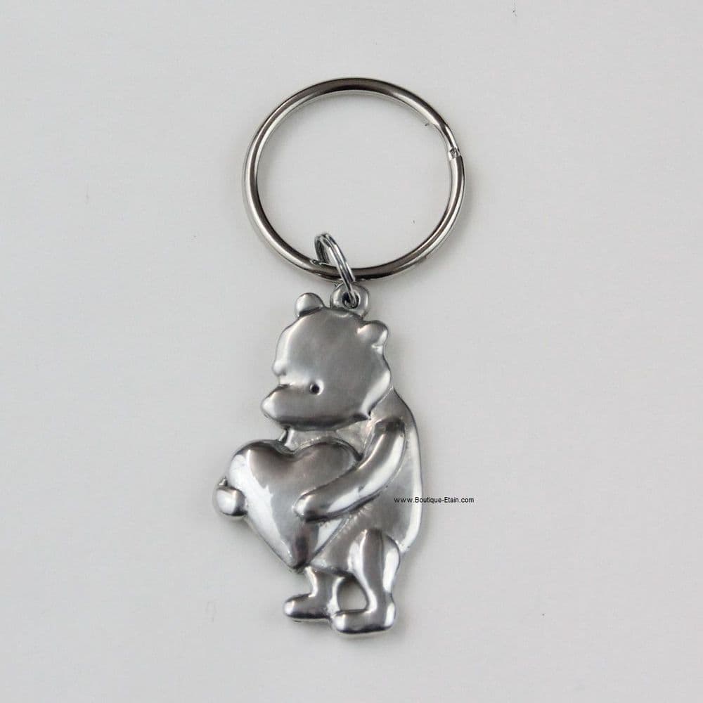 Porte-clés ou porte-clefs Winnie l'Ourson tient un coeur en étain.