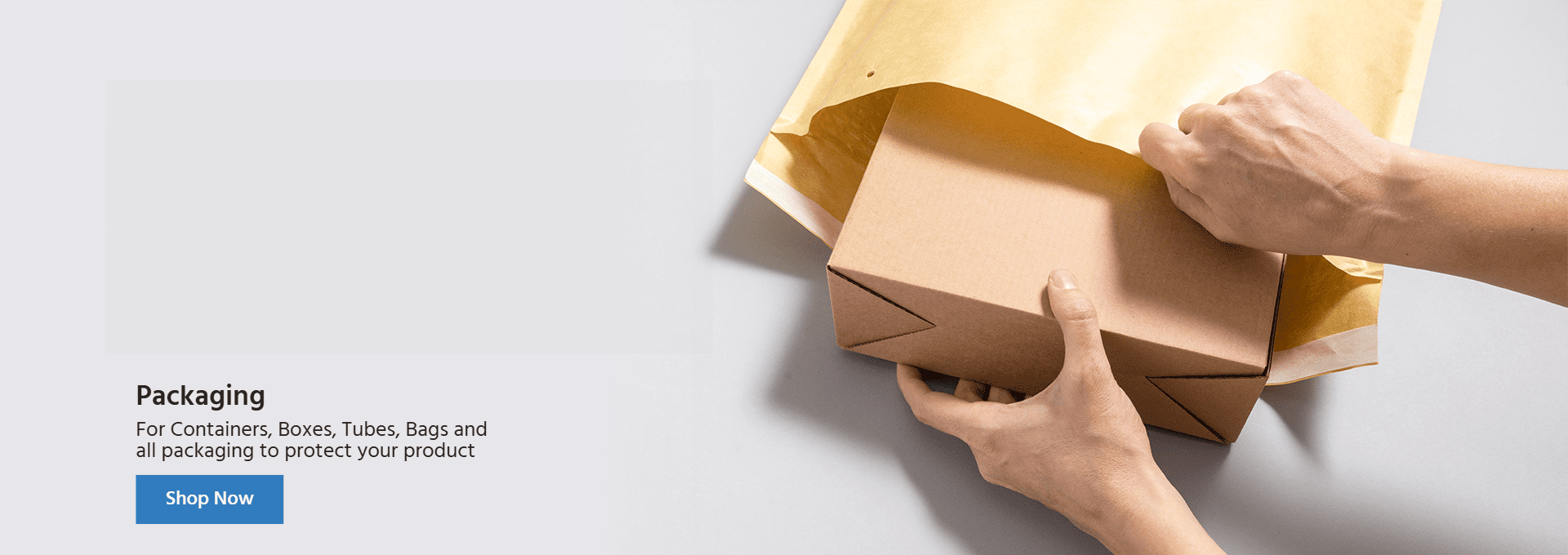 Cardboard box being placed in a brown padded envelope