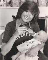 Cilla Bottle Feeding Baby in Liverpool Jumper Press Photo