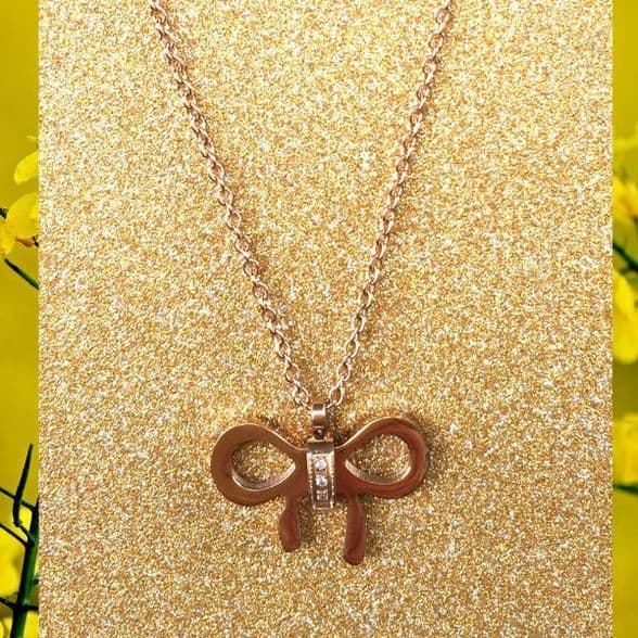 A beautiful butterfly pendant made of mother of pearl and emblazoned with small glittering crystals on a gold metal base. J020010