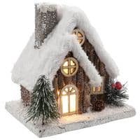 Christmas Forest illuminated Chalet House with a Snow Covered Roof