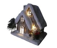 Christmas Forest illuminated Chalet House with a Snow Covered Roof