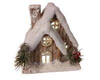 Christmas Forest illuminated Chalet House with a Snow Covered Roof