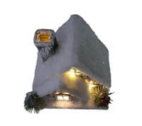 Christmas Forest illuminated Chalet House with a Snow Covered Roof