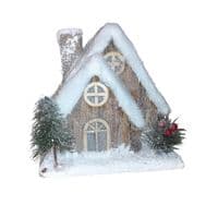 Christmas Forest illuminated Chalet House with a Snow Covered Roof