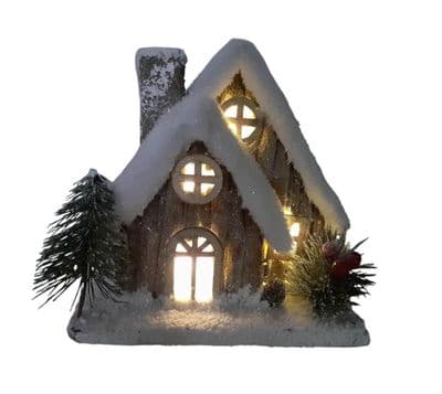 Christmas Forest illuminated Chalet House with a Snow Covered Roof