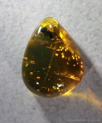 Amber cabochon with Acacia flower inclusion, Dominican Republic.  8.29 carats.
