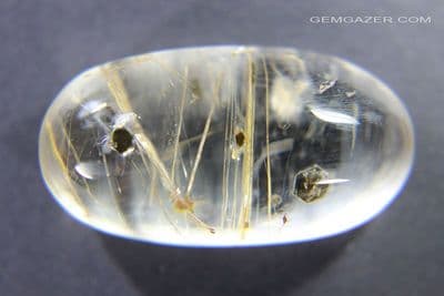 Quartz cabochon with Fuchsite Mica and Rutile needle inclusions, China.  30.84 carats.