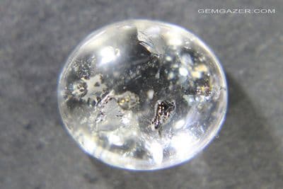 Quartz cabochon with iridescent Antimony inclusions, Brazil.  4.96 carats.
