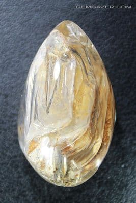 Quartz cabochon with layered Lodolite inclusions, China. 66.02 carats.