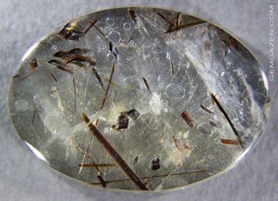 Quartz doublet cabochon with Astrophyllite inclusions.  23.90 carats.