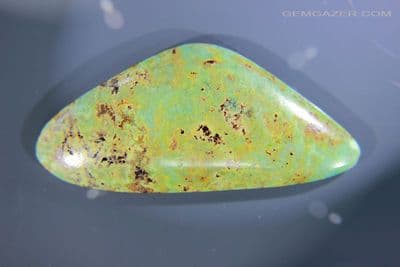 Quartzite cabochon with Chrysocolla, Scapolite, Sphene, etc, Peru. 115.55 carats.