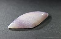 Tremolite, var: Hexagonite, purple and colourless cabochon. USA.   29.70 carats.