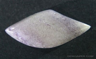 Tremolite, var: Hexagonite, purple and colourless cabochon. USA.   29.70 carats.
