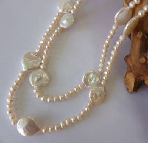 Large coin-shaped pearls on a 36 inch string of small round pearls.