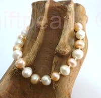 White and pink pearl bracelet with golden filigree clasp.