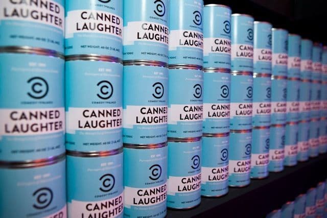 Labelled empty tin cans displayed in a television studio set as a backdrop