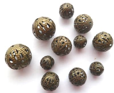 Hollow spacer beads x 11. 4 sizes - 7mm - 14mm. Antique Bronze