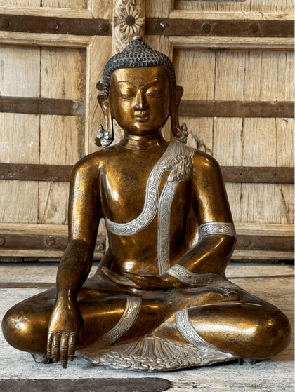 gold and silver plated bronze buddha in meditation with hand mudras in the bhumisparsha pose