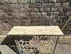 vintage iron console with faded paint tones and inset marble top