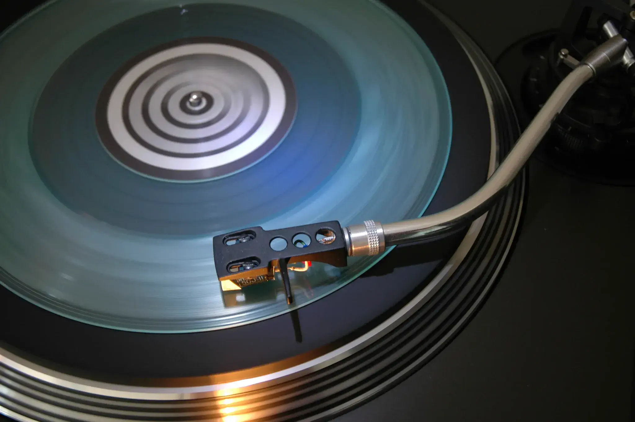 Close-up of a vinyl record playing on a turntable for the Planet Earth Records condition grading guide.