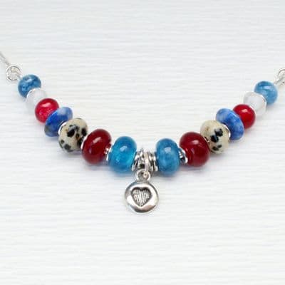 Handmade necklace featuring a silver heart pendant and various blue and red  gemstones.