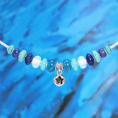 Handmade necklace featuring a silver star pendant and various blue gemstones.