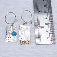 Handmade sterling silver asymmetrical earrings, featuring a blue Opal gemstone, embossed silver.  .