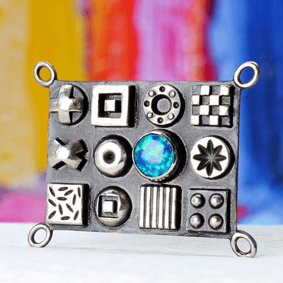 Solid sterling silver oxidised brooch with raised 3D polished symbols and a beautiful blue Opal