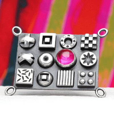 Solid sterling silver oxidised brooch with raised 3D polished symbols and a pink corundum gemstone
