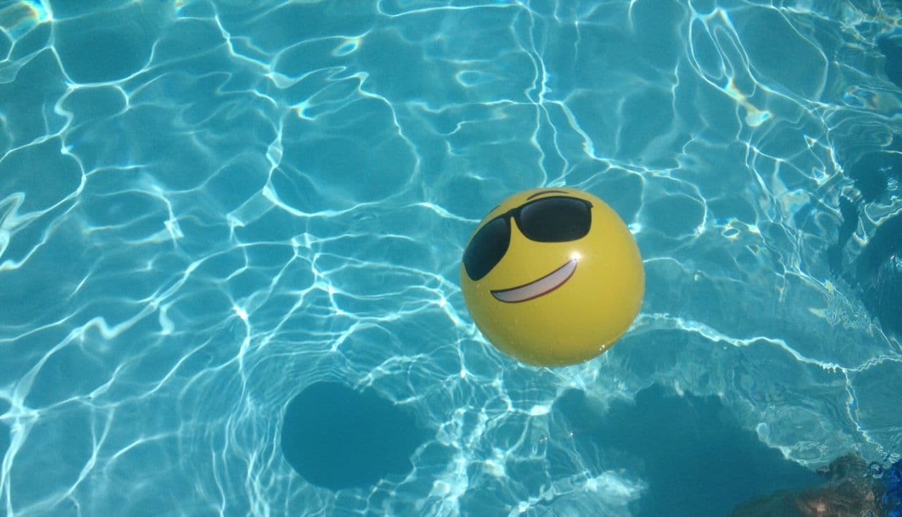 shades emoji beach ball in pool